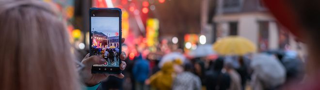 Foto zeigt eine Frau, die mit ihrem Smartphone ein Konzert filmt
