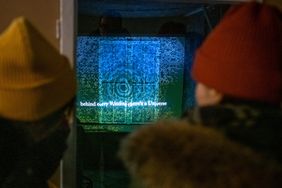 Impression der Winterwerkschau 2020: zwei Personen betrachten eine Projektion im Freien; Foto Thomas Müller