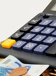 A calculator with money in front of it