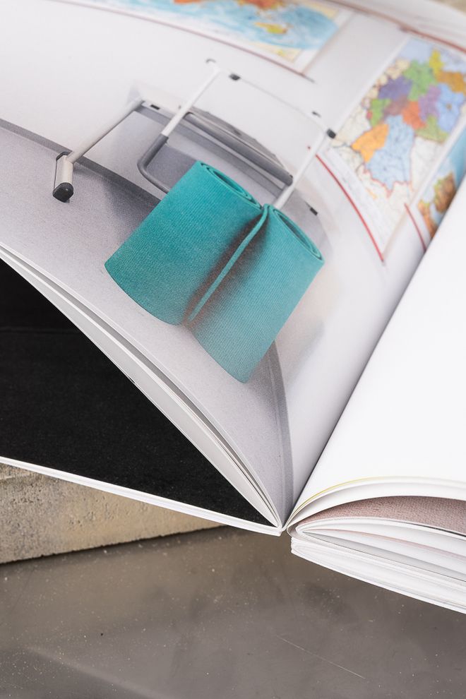 Aufgeschlagene Publikation »Durch Fotografie keine Einsichten« mit fotografischer Arbeit und Alltagsgegenständen