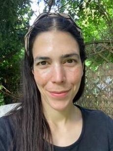 Selfie von Denise Blickhahn. Sie hat lange dunkelbraune Haare, trägt ein grau-schwarzes Haarband und ein anthrazitfarbenes T-Shirt. Sie lächelt in die Kamera. 