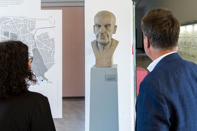 Jürgen Dusel und Michaela Albrecht stehen vor einer Büste von Walter Gropius im Foyer des Hauptgebäudes. Der Bildhauer Siegfried Tschierschky (1898 – 1965) war Professor für Bauplastik und Leiter der Abteilung Bildende Kunst an der Hochschule für Architektur und Bauwesen Weimar und gilt als der Wegbereiter durchbruchplastischer Wände in Architekturfassaden. Zusammen mit Kurt Grohmann (1928 – 1974) schuf er 1957 die beiden Büsten der geistigen Väter des Gebäudes: Henry van de Velde als Architekt der Kunstschulbauten und Walter Gropius als Begründer des Bauhauses.