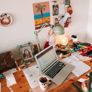 Desk with a laptop and all sorts of bits and pieces