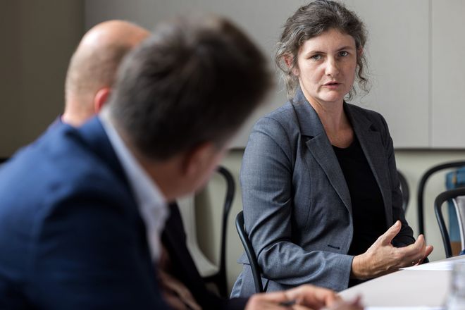 Die Diversitätsbeauftragte der Universität, Dr. Miriam Benteler, im Gespräch. Im Vordergrund des Fotos sind unscharf Jürgen Dusel sowie Vizepräsident Dr. Simon Frisch, die ihr zuhören.