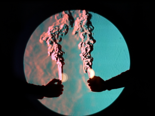 Mithilfe des Schlierenverfahrens werden kleinste Luftströmungen sichtbar, hier demonstriert mit zwei Feuerzeugen. (Foto: Amayu Wakoya Gena, DAAD-Stipendiat Professur Bauphysik)