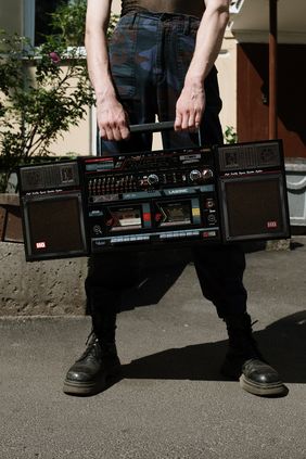 Foto von cottonbro von Pexels ein junger Mens hält einen Ghettoblaster