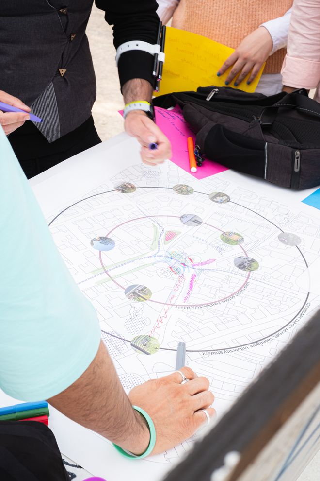mehrere Personen beugen sich über einen Plan der Innenstadt Weimars und zeichnen Dinge ein