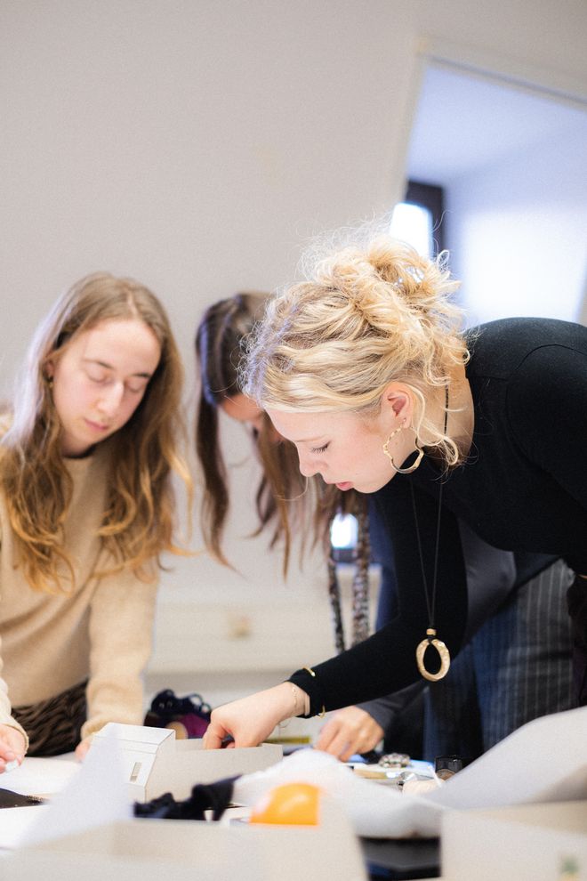 mehrere Personen arbeiten stehend gemeinsam an ihren Projekten