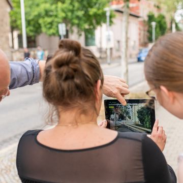 Heinricht Söbke, Anne Krause und Carolin Schwarz testen die App »AugView« in der Amalienstraße. Fotografiert von Thomas Müller.