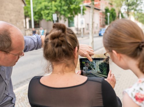 Heinricht Söbke, Anne Krause und Carolin Schwarz testen die App »AugView« in der Amalienstraße. Fotografiert von Thomas Müller.