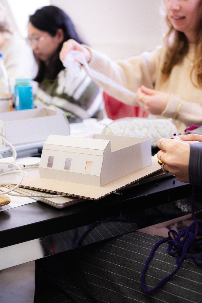 mehrere Personen arbeiten an Tischen an Modellen