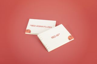 Product view of »RED AF* – Red Asian Flush« by Soo Ah Youn and Anastasia Fast: two closed, thread-bound books lie on a red background. The light-coloured covers show the titles »RED ASIAN FLUSH« and »RED AF*«.