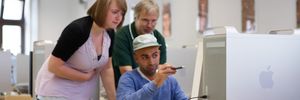 Studierende sitzen vor einem Computer