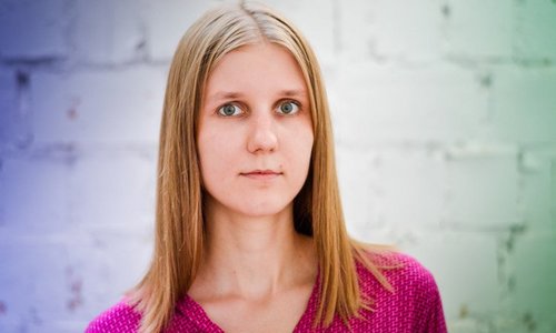 Das farbige Porträt-Foto zeigt Galyna Sukhomud von den Schultern aufwärts. Sie hat glattes, schulterlanges blondes Haar und graugrüne Augen. Sie trägt ein himbeerrotes Oberteil mit einem geometrischen Muster aus weißen Linien.