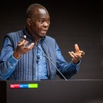 Prof. Diébédo Francis Kéré steht am Redepult und hält einen Vortrag
