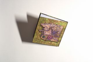 A closed, hand-bound picture book lies on a light background. The cover shows a colourful illustration with handwritten text.