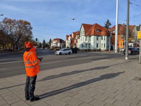 Mann steuert eine Drohne über einer Kreuzung