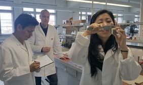 Dipl.-Ing. Christoph Kulle mit den Gästen Jamyang Dukjey und Karma Euthra in den Laboren der Professur Bauchemie und Polymere Werkstoffe bei der Untersuchung der kapillaren Wasseraufnahme von zementstabilisierten Lehmsteinen, Foto: Karma Tenzin
Dipl.-Ing. Christoph Kulle mit den Gästen Jamyang Dukjey und Karma Euthra in den Laboren der Professur Bauchemie und Polymere Werkstoffe bei der Untersuchung der kapillaren Wasseraufnahme von zementstabilisierten Lehmsteinen, Foto: Karma Tenzin