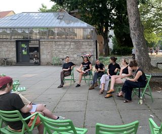 Das Foto zeigt die sechs Diskutant*innen der Podiumsdiskussion im Gespräch im Hof vor dem Bauhaus.Atelier.