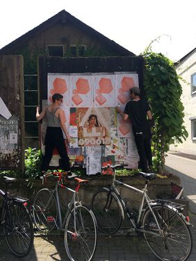 Studierenden hängen Plakate zum Projektil-Festival auf