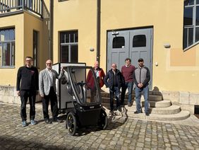 Travel sustainably starting now: Chancellor Dr. Horst Henrici (2nd from left) hands over the new electric cargo bikes to the MTS team in front of the university’s Main Building. Photo: Marit Haferkamp