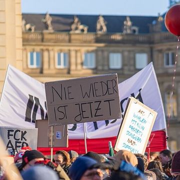 Plakate auf einer Demo (Copyright: Alex Fremer, CC BY-SA 2.0 <https://creativecommons.org/licenses/by-sa/2.0>, via Wikimedia Commons)