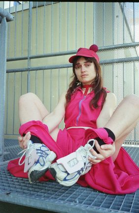 Analoge Fotografie von einer jungen Frau im pinken Kleid, das im Rahmen des Fachkurses »Dress Code« von Bakalao Pecado entstanden ist 