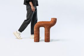 Foto des Sitzmöbels; im Anschnitt die Beine einer Person, die vorbei läuft.