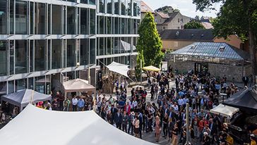 Eine Menge Menschen im Innehof des Campus hinter dem Hauptgebäude.