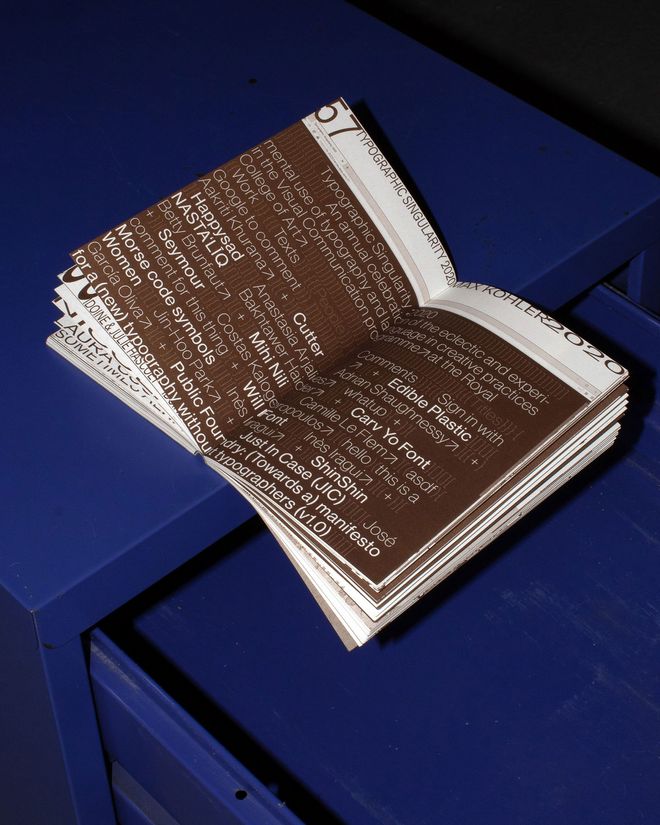 Open publication on a blue surface. A brown page shows a dense collection of terms, names and typographic elements in different sizes.