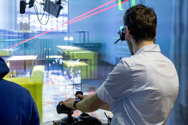 Anton Benjamin Lammert, wissenschaftlicher Mitarbeiter an der Professur Virtuelle Realität und Visualisierung, demonstrierte den Besuchern bei der Langen Nacht der Wissenschaften 2024 die Möglichkeiten im Virtual Reality Labor. Foto: Matthias Eckert