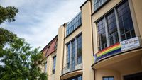 Das Foto zeigt ein Banner mit der »Inter*-inklusiven Progress-Pride-Flagge« am Hauptgebäude der Bauhaus-Universität Weimar.