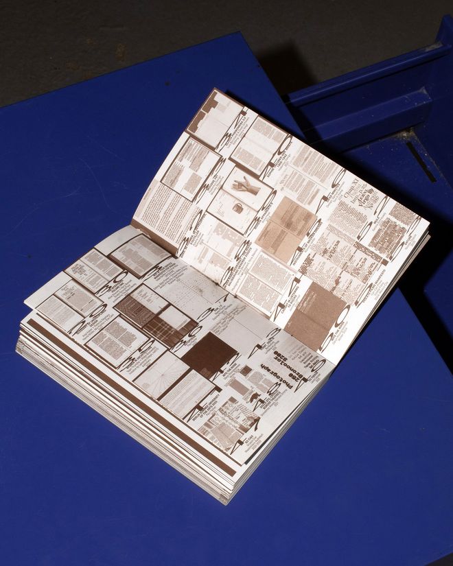 Open publication on a blue surface. The double page shows numerous examples of typographic emphasis, including text boxes, markings, images and different uses of type.