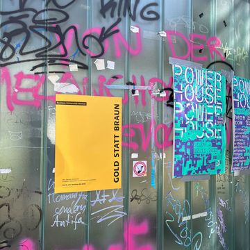 Plakat der Aktion »Gold statt Braun« an einer mit Graffiti besprühten Glaswand