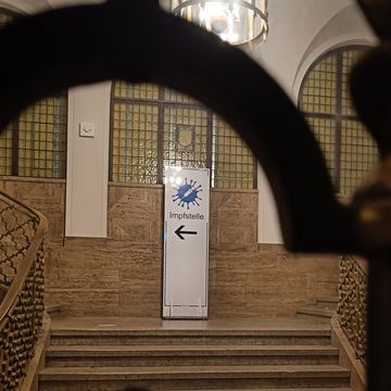 Schild mit der Aufschrift "Impfstelle" im Treppenhaus der Notenbank