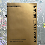 Goldenes Plakat vor einer dunkelgrauen Tür, daneben kleben Sticker.