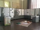 Fotografie einer Ausstellung mit Plakaten und einem Teppich zum Hinsetzen in der Mitte des Ausstellungsraums