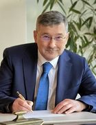 (c) Michael Liebert Ein Mann sitzt am Schreibtisch und blickt freundlich in die Kamera
