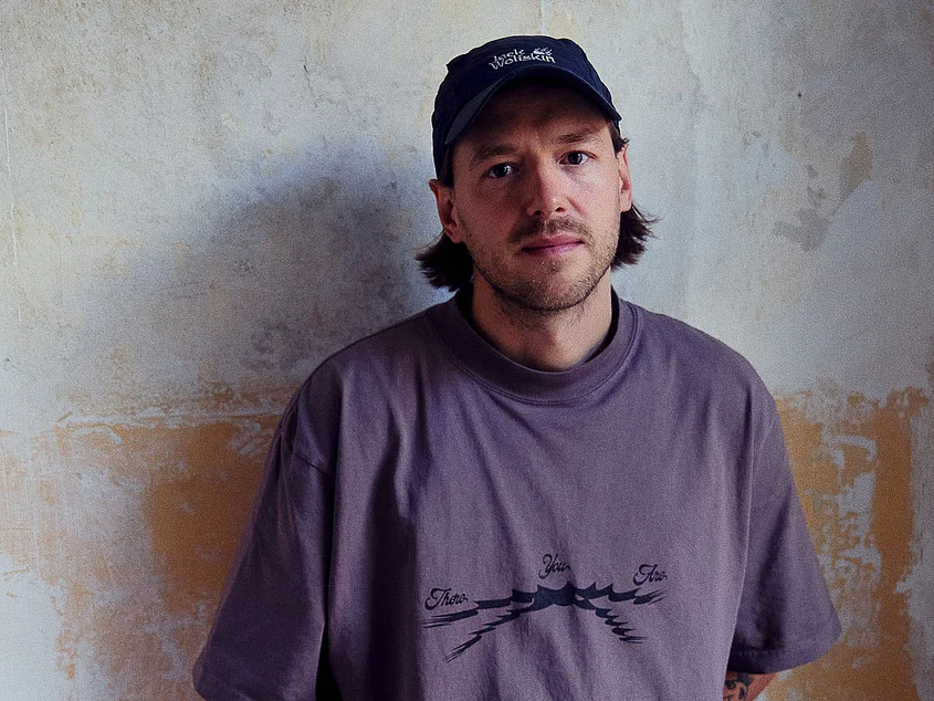 Portrait of Frieder Oelze in front of a textured wall, photographed by Matthias Leidinger