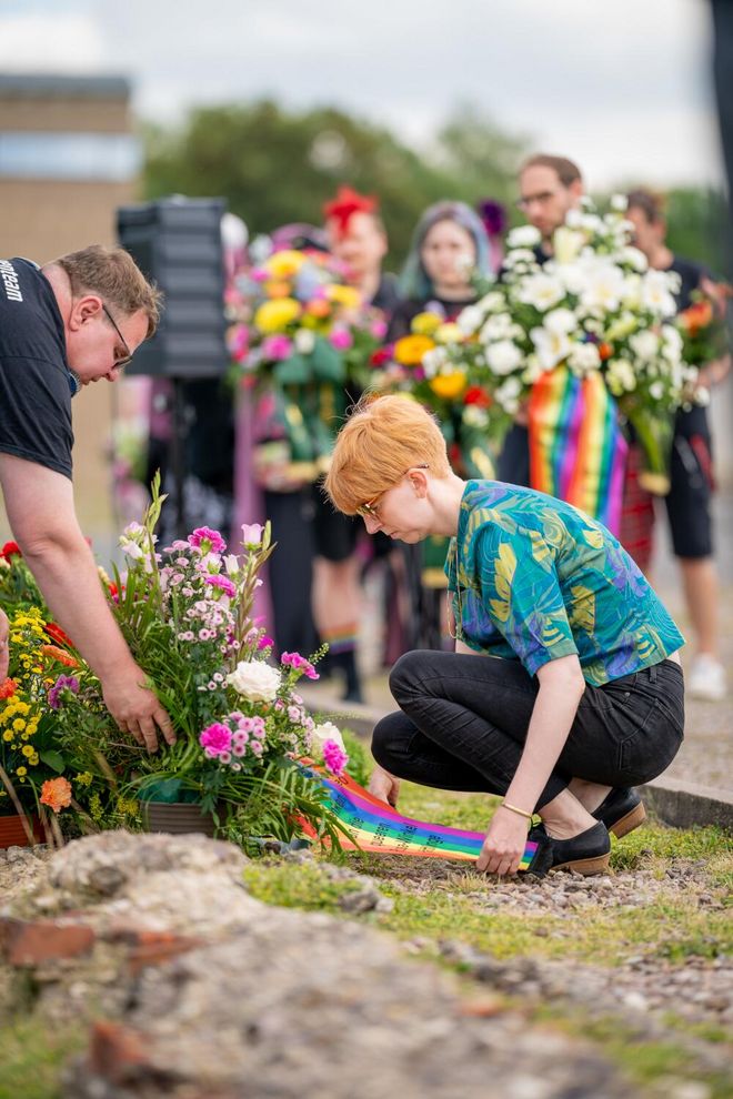 Jessica Daschkeit lays down a mourning bouquet by the memorial stone for the »Pink Triangle Prisoners«