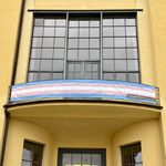 Banner in the colors of the Trans Pride flag on the balcony of the Main Building.