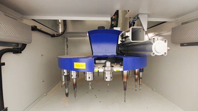 Werkzeugwechsler im Innenraum einer CNC-Fräsmaschine mit mehreren eingespannten Fräswerkzeugen unterschiedlicher Größe.