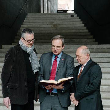 Der Künstler (v.l.) Axel Malik, Dr. Frank Simon-Ritz, Direktor der Universitätsbibliothek und Frank Matzky, Vorsitzender des Hilfsfonds des Rotary-Clubs Weimar, begutachten das neuerworbene Tagebuch aus der »Bibliothek der unlesbaren Zeichen«. (Foto: Candy Welz)