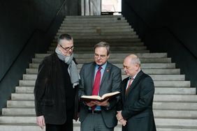 Der Künstler (v.l.) Axel Malik, Dr. Frank Simon-Ritz, Direktor der Universitätsbibliothek und Frank Matzky, Vorsitzender des Hilfsfonds des Rotary-Clubs Weimar, begutachten das neuerworbene Tagebuch aus der »Bibliothek der unlesbaren Zeichen«. (Foto: Candy Welz)