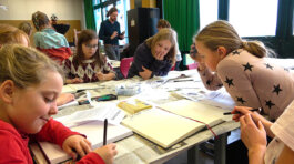 Kinder sitzen an einem Tisch und arbeiten mit Papier und Stift SPECTRA Bauhaus Universität Weimar