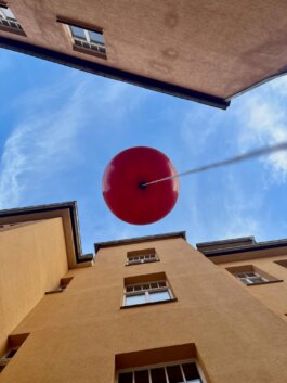 roter Luftballon zwischen Gebäuden, blauer Himmerl SPECTRA Bauhaus Universität Weimar