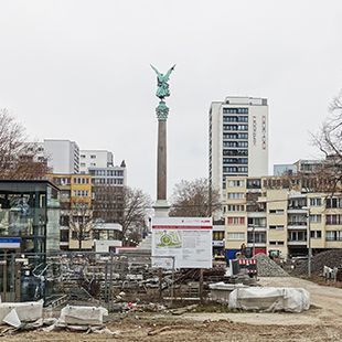 Mehringplatz in der Südlichen Friedrichstadt. Die Sozialbausiedlung wurde in den 1960er Jahren nach Entwürfen von Hans Scharoun in Erinnerung an den früheren, im Zuge des Zweiten Weltkrieges zerstörten Platz gestaltet. Die ausgedehnte Fußgängerzone – derzeit unter Sanierung - bildet den Kern des Wohnquartiers. In der Mitte erhebt sich die 1843 eingeweihte Friedensäule. / Piero Sassi 2021 Mehringplatz in der Südlichen Friedrichstadt. Die Sozialbausiedlung wurde in den 1960er Jahren nach Entwürfen von Hans Scharoun in Erinnerung an den früheren, im Zuge des Zweiten Weltkrieges zerstörten Platz gestaltet. Die ausgedehnte Fußgängerzone – derzeit unter Sanierung - bildet den Kern des Wohnquartiers. In der Mitte erhebt sich die 1843 eingeweihte Friedensäule. / Piero Sassi 2021